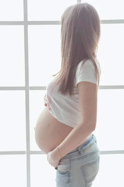 Un primer plano de una linda barriga embarazada. Concepto de maternidad femenina embarazada . — Foto de Stock