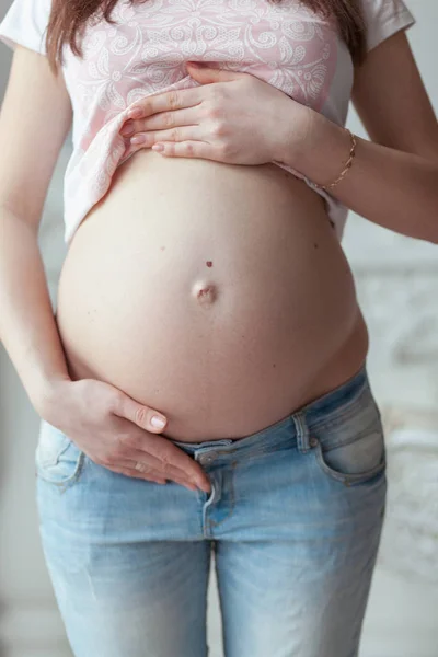 Mujer embarazada de siete meses en jeans. Vista frontal de cerca — Foto de Stock