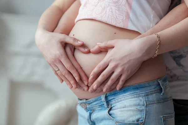 Para, Dokonywanie kształcie serca na brzuchu w ciąży z ich rąk. Koncepcja ciąży. — Zdjęcie stockowe