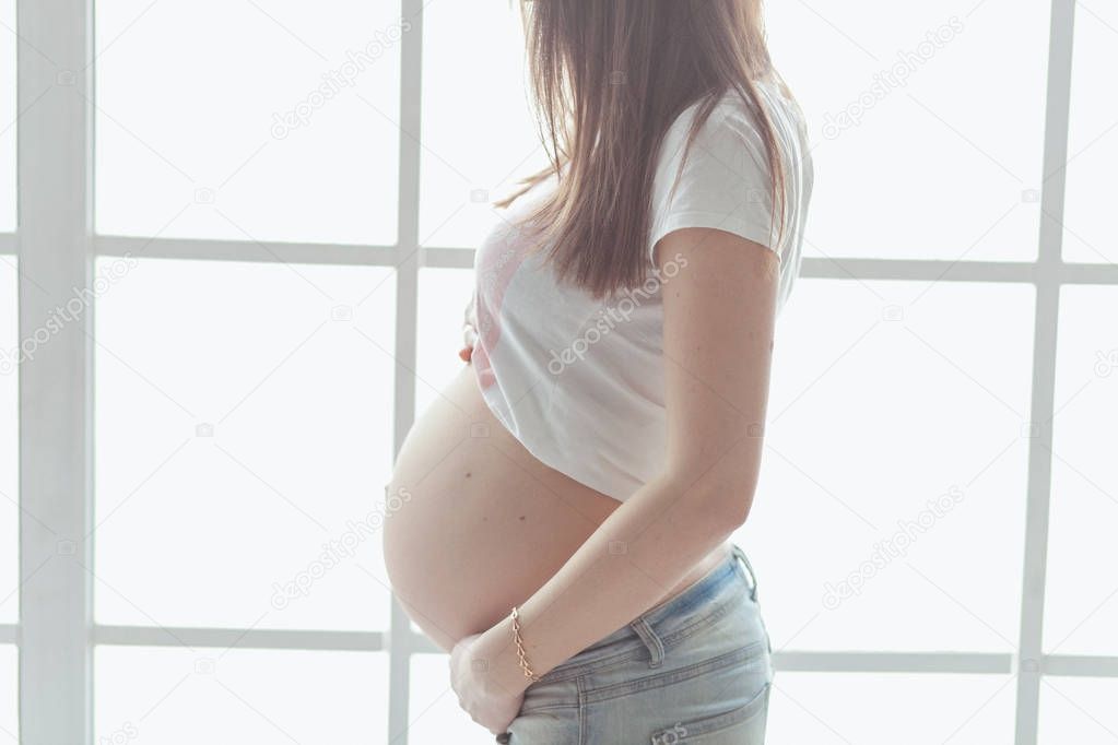 Close up of a cute pregnant belly. Pregnant female motherhood concept.