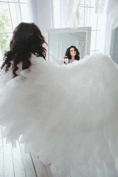 Una mujer embarazada. Foto romántica portait de la hermosa chica morena posando en lencería blanca sexy mirando a la cámara en casa . — Foto de Stock