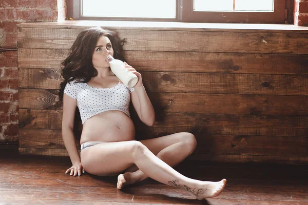 Mulher grávida segurando garrafa de leite. Nutrir o feto e seu corpo para se manter saudável e sempre . — Fotografia de Stock