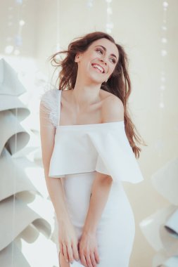 Güzel genç model gülümseyen ve fotoğraf stüdyosu, moda kumaş Noel ağacı arka plan üzerinde poz.