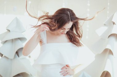 aşağı bakıyor beyaz elbiseli güzel esmer kadın. Noel arifesi için moda photosession