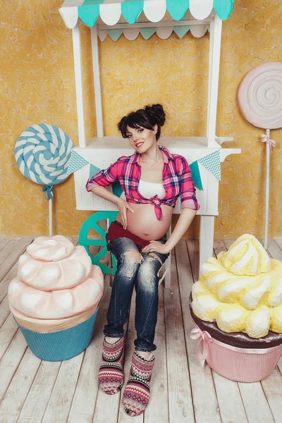 Happy pregnant woman in toy candybar Stock Image