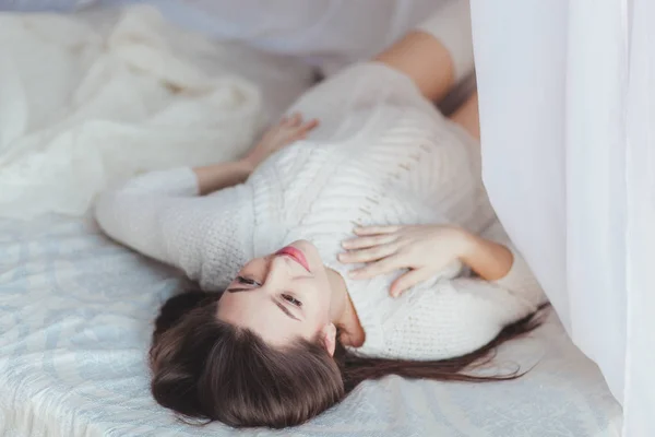 Przetargu w ciąży kobieta leżąc na łóżku z baldachimem tule — Zdjęcie stockowe