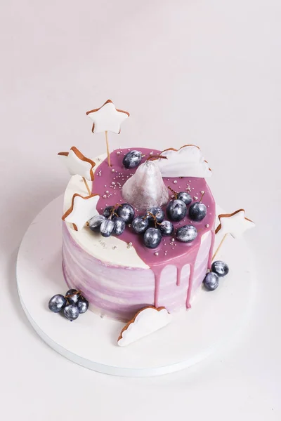 Modny Lila okrągłe ciasto mus z mirror glaze, gruszki, winogrona i Piernik urządzone. na białym tle na szarym tle. Widok z bliska — Zdjęcie stockowe