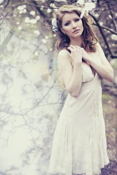 Lente vrouw met bloemen in haar haar. Schoonheid Lady portret mode Brunette meisje met Magnolia bloemen kapsel. — Stockfoto