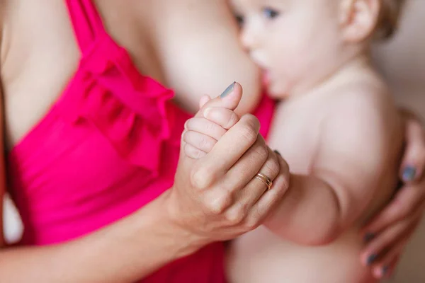 Foco suave e embaçado das mãos do bebê tocam a mão da mãe enquanto amamentam — Fotografia de Stock