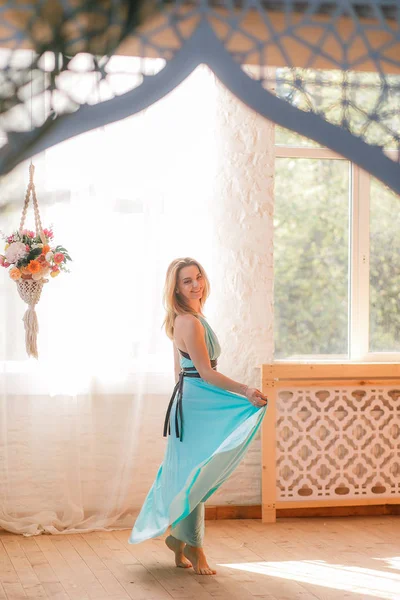 Menina dança em um grande salão na frente das janelas — Fotografia de Stock