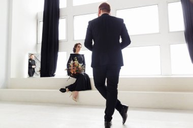 Gelin ve damat siyah takım elbiseli. Aynaya yansıtan. Windows ile beyaz Stüdyo Oda