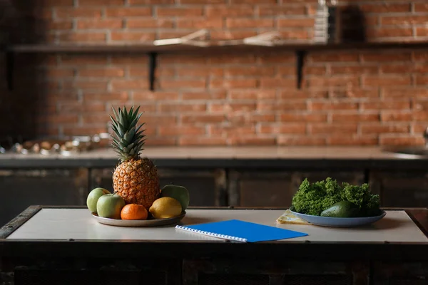 Concepto de dieta de desintoxicación de frutas y verduras. Manzana fresca, limón, piña, aguacate en la mesa de madera en la cocina con fondo de pared de ladrillo loft — Foto de Stock