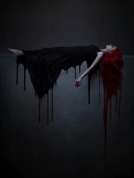 黒のドレスに赤い髪の女性 ストック画像