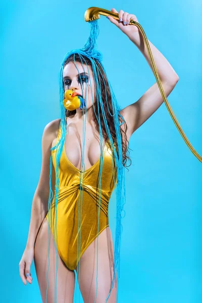 Frau im goldenen Badeanzug mit gelber Ente — Stockfoto