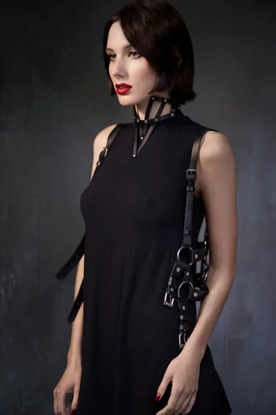 Femme en robe noire avec accessoires en cuir — Photo