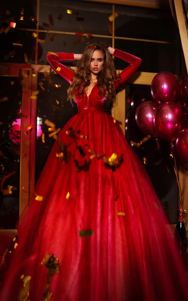 Жінка Червоній Вечірній Сукні Позує Святковому Фоні — стокове фото