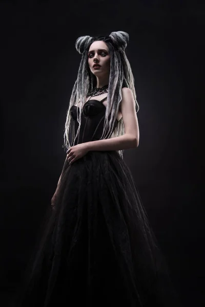女人与害怕和黑色的哥特式礼服摆在黑暗的背景 — 图库照片
