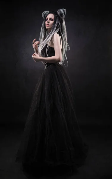 女人与害怕和黑色的哥特式礼服摆在黑暗的背景 — 图库照片