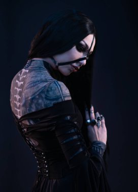 Gotik tarzda siyah elbiseli genç bir kadın. 