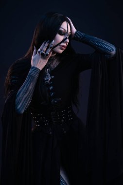 Gotik tarzda siyah elbiseli genç bir kadın. 