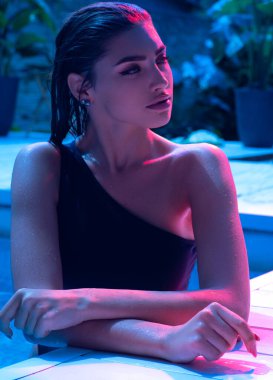 Moda fotoğrafçılığı. Yüzme havuzunda poz veren genç bir model