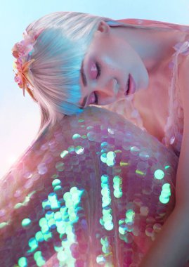 Moda fotoğrafçılığı. Stüdyoda güzel bir elbiseyle poz veren genç bir model