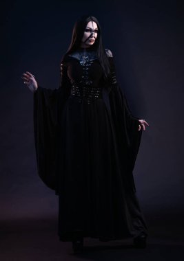 Gotik tarzda siyah elbiseli genç bir kadın. 