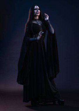 Gotik tarzda siyah elbiseli genç bir kadın. 