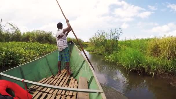 Madagaskaru człowiek ze wsi na Madagaskar rzeki Antainambalana pomaga jazdy łódź transportu towarowego — Wideo stockowe