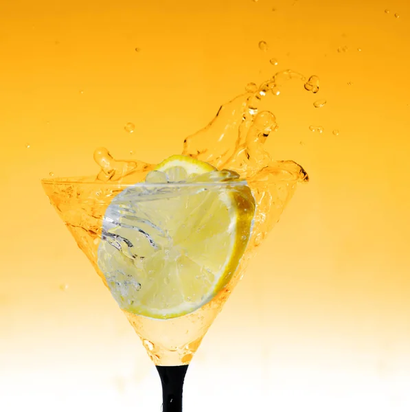 Свежий лимон в стакане с брызгами воды — стоковое фото