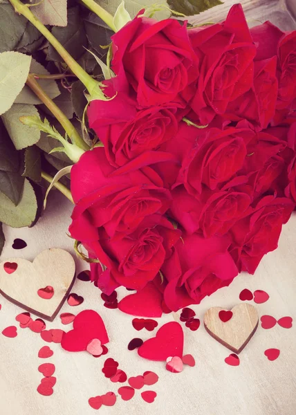 Pequeños corazones rojos de San Valentín y rosas frescas — Foto de Stock