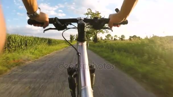 Montar en una bicicleta MRB (Bicicleta) en el campo de verano por la noche — Vídeos de Stock