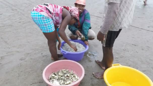 Коренные рыбаки рыбачат в море, женщина выбирает ловленную рыбу — стоковое видео