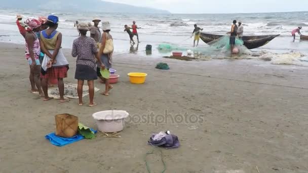 Коренные рыбаки рыбачат в море, женщина выбирает ловленную рыбу — стоковое видео