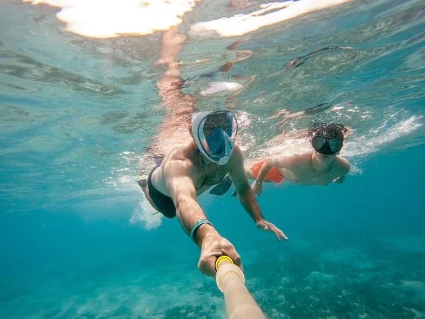 Father and son snorkel in shallow water on coral fish — Stock Photo, Image