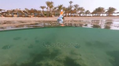 Kadın şnorkel mercan balık ile sığ suda yüzmek