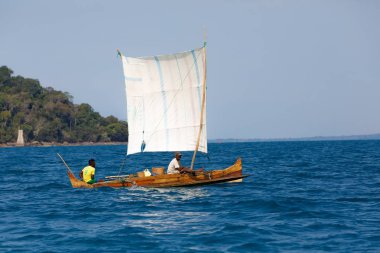 Geleneksel el yapımı sığınağın ahşap sailin içinde deniz üzerinde Madagaskar adam