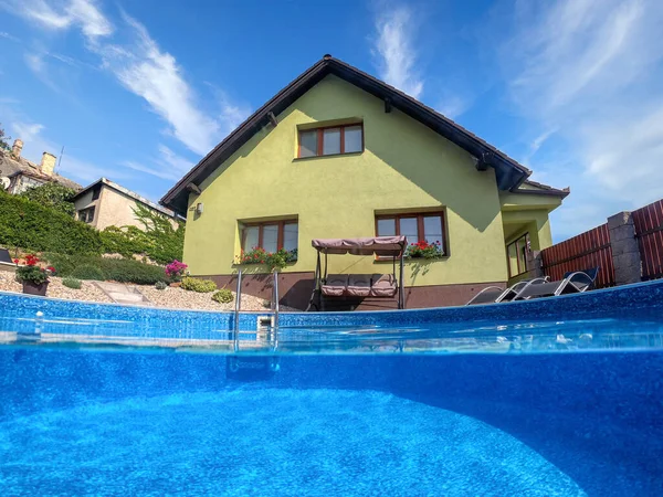 Klein Huis Zwembad Met Twee Zwarte Ligstoelen Schommelbank Onderwater Split — Stockfoto