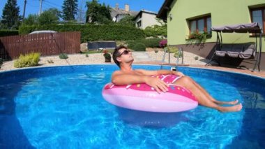 Mutlu adam şişme yüzüğün üzerinde rahatla. Tatil 2020
