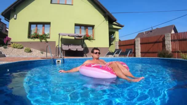 Hombre feliz relajarse en el anillo inflable. Vacaciones 2020 — Vídeo de stock