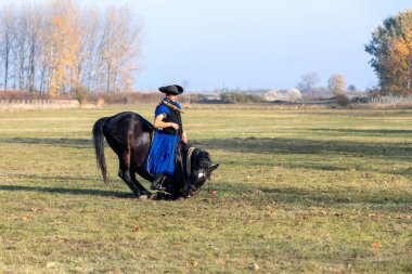 Hortobeage, Hungary, Kasım, 04 'te. 2018: Geleneksel halk kostümlü Macar kaçıklar eğitimli atını gösteriyor. Macaristan 'ın geleneksel at çobanı. Kasım 04. 2018, Hortobagy, Macaristan