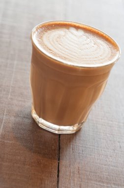 Tablo üzerinde beyaz bir fincan sıcak kahve. kabarcık süt belli değil