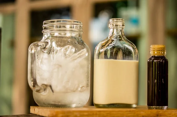 Milch, Eis und Kaffee im Glas auf dem Tisch — Stockfoto