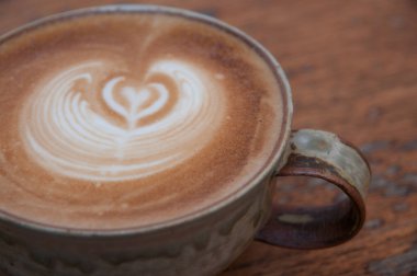 Tablo üzerinde beyaz bir fincan sıcak kahve. kabarcık süt belli değil