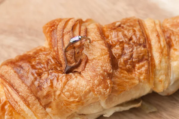 Croissant au beurre cuit et anneau sur bois — Photo