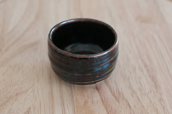 Copo cerâmico de barro na mesa de madeira — Fotografia de Stock