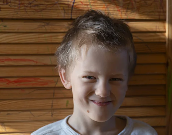 これは木製の背景に金髪の少年の肖像画です — ストック写真