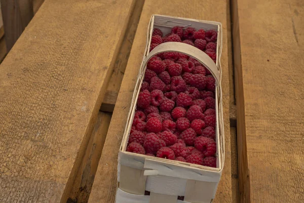 Bunlar ahşap bir arka planda sepetteki olgun ahududular.