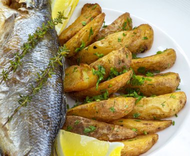 Tabakta kızarmış patates ve ringa balığı var.