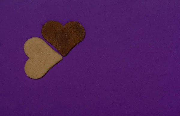 2つのハートクッキーはバレンタインデーの紫色の背景にあります — ストック写真